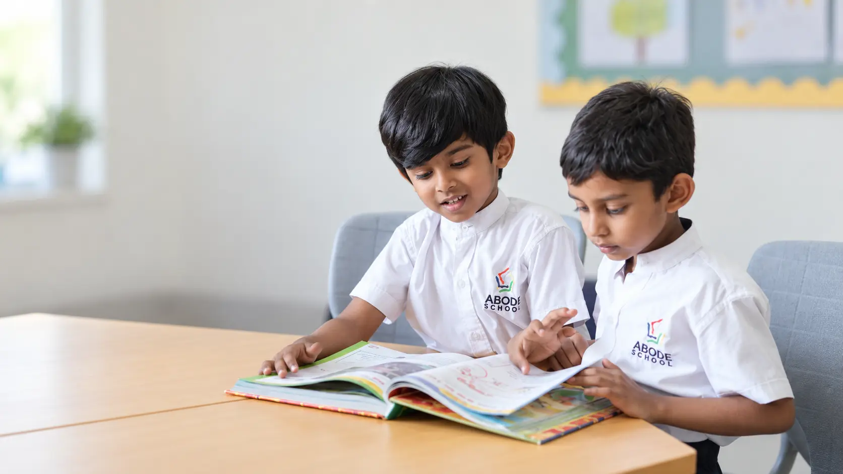 Two ABODE students reading a book together