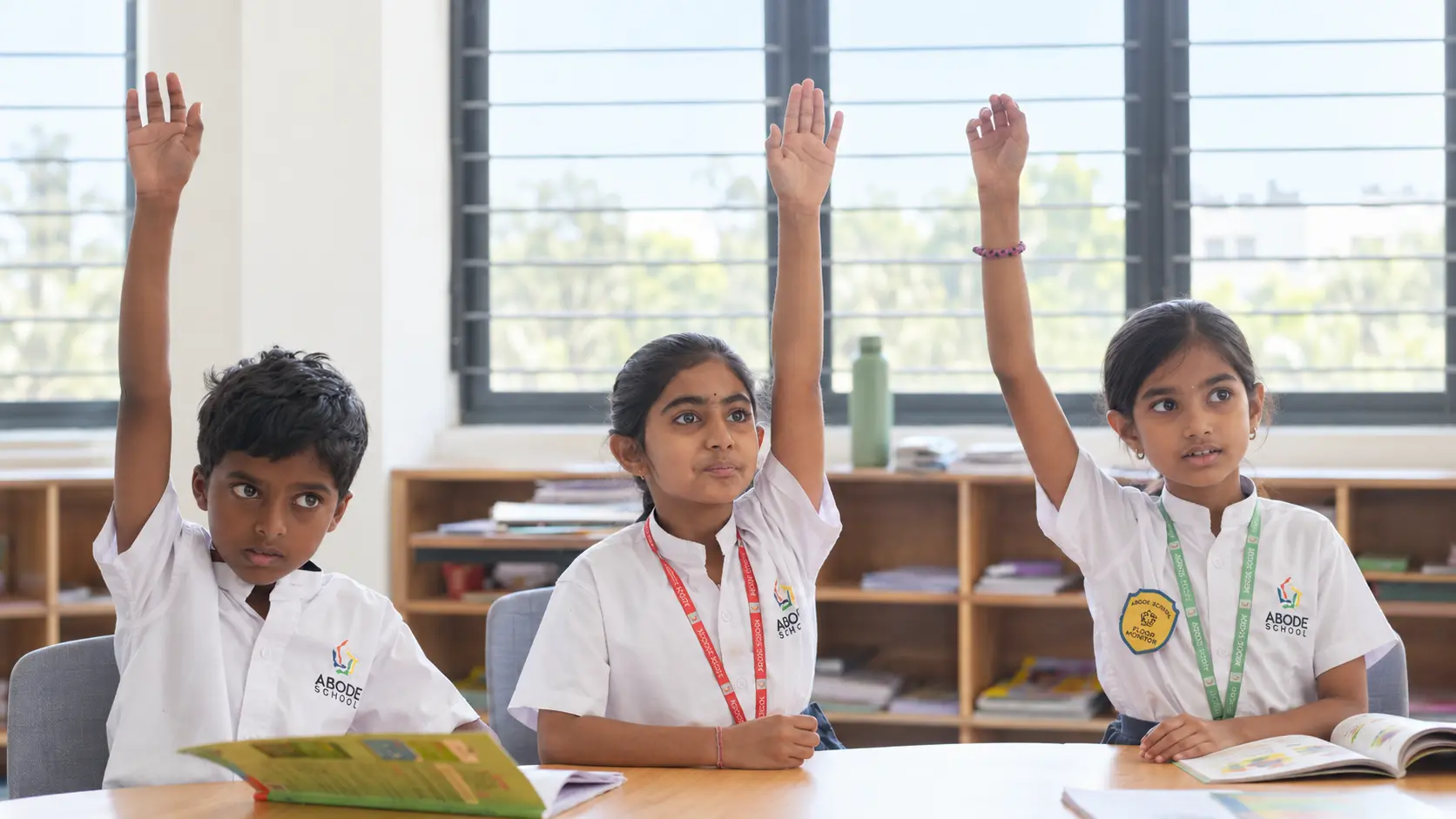ABODE students raising their hands in class